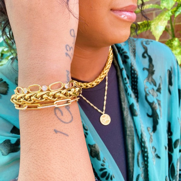 Model styling Bold & Edgy Chain Bracelet with layered gold bracelets and necklace