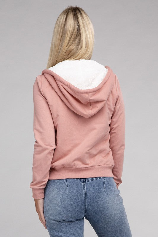 Mauve cropped zip-up hoodie with fuzzy trim, pockets, and long sleeves.