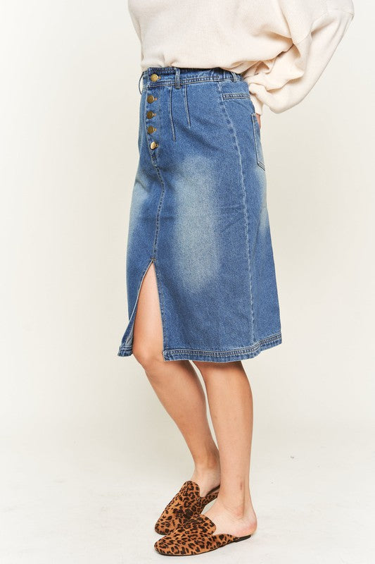 Denim button-down midi skirt with a front slit, belt loops, and back pockets. Features a high waist with an elasticized waistband in the back.