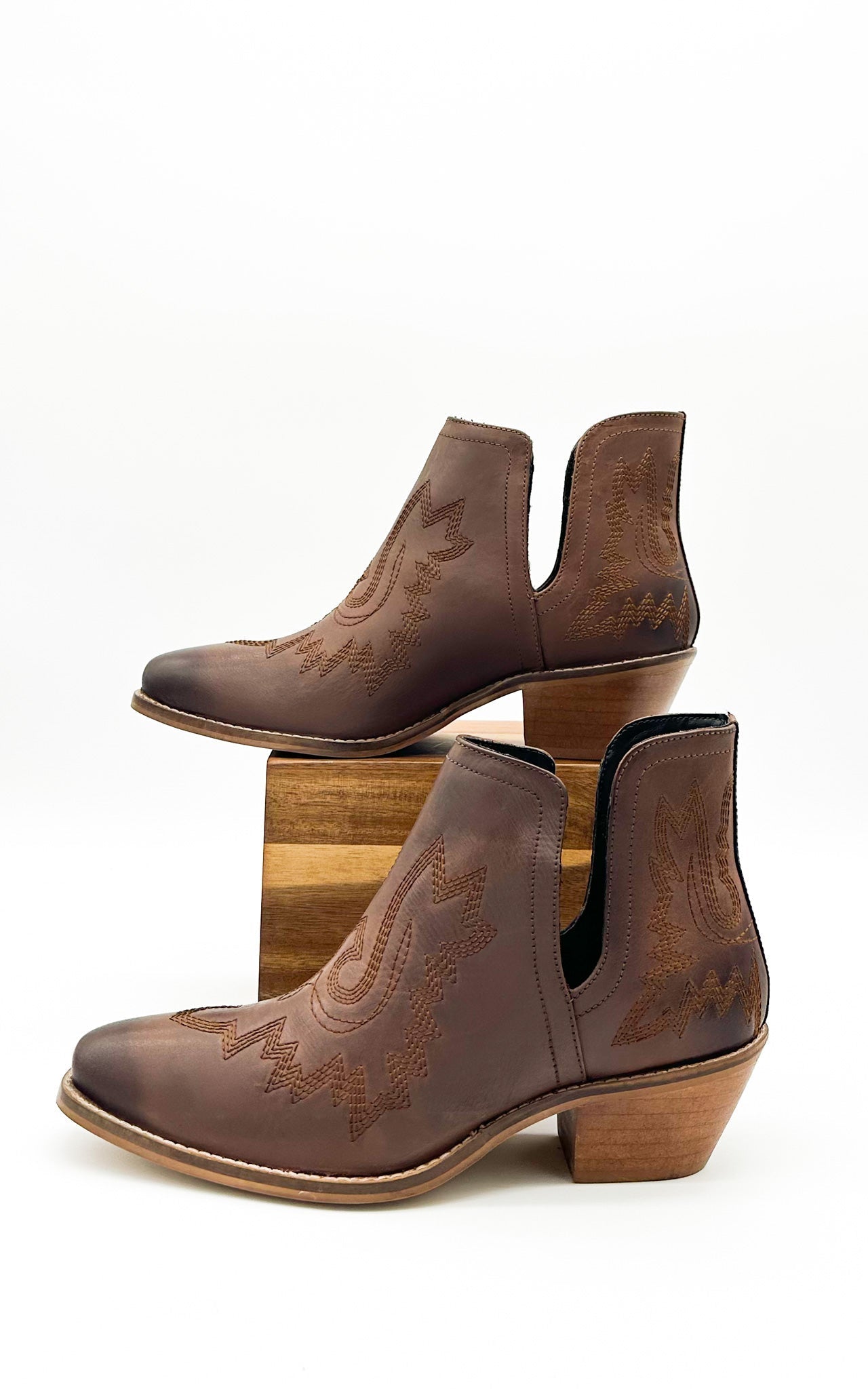 Brown leather booties with Western embroidery, roomy snip toe, cushioned footbed, and ankle slits.