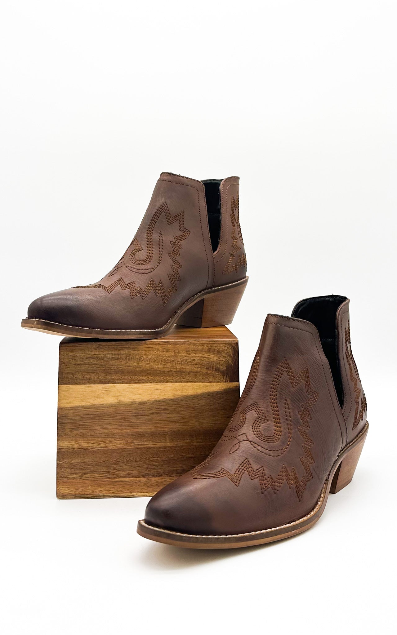 Brown leather booties with Western embroidery, roomy snip toe, cushioned footbed, and ankle slits.