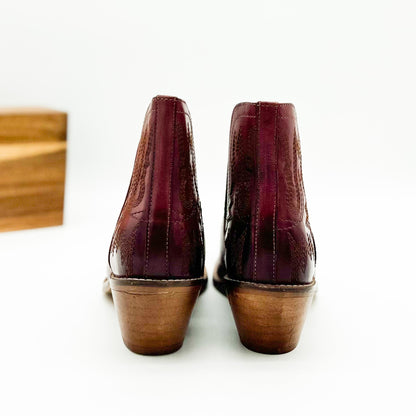 Burgandy leather booties with Western embroidery, roomy snip toe, cushioned footbed, and ankle slits.