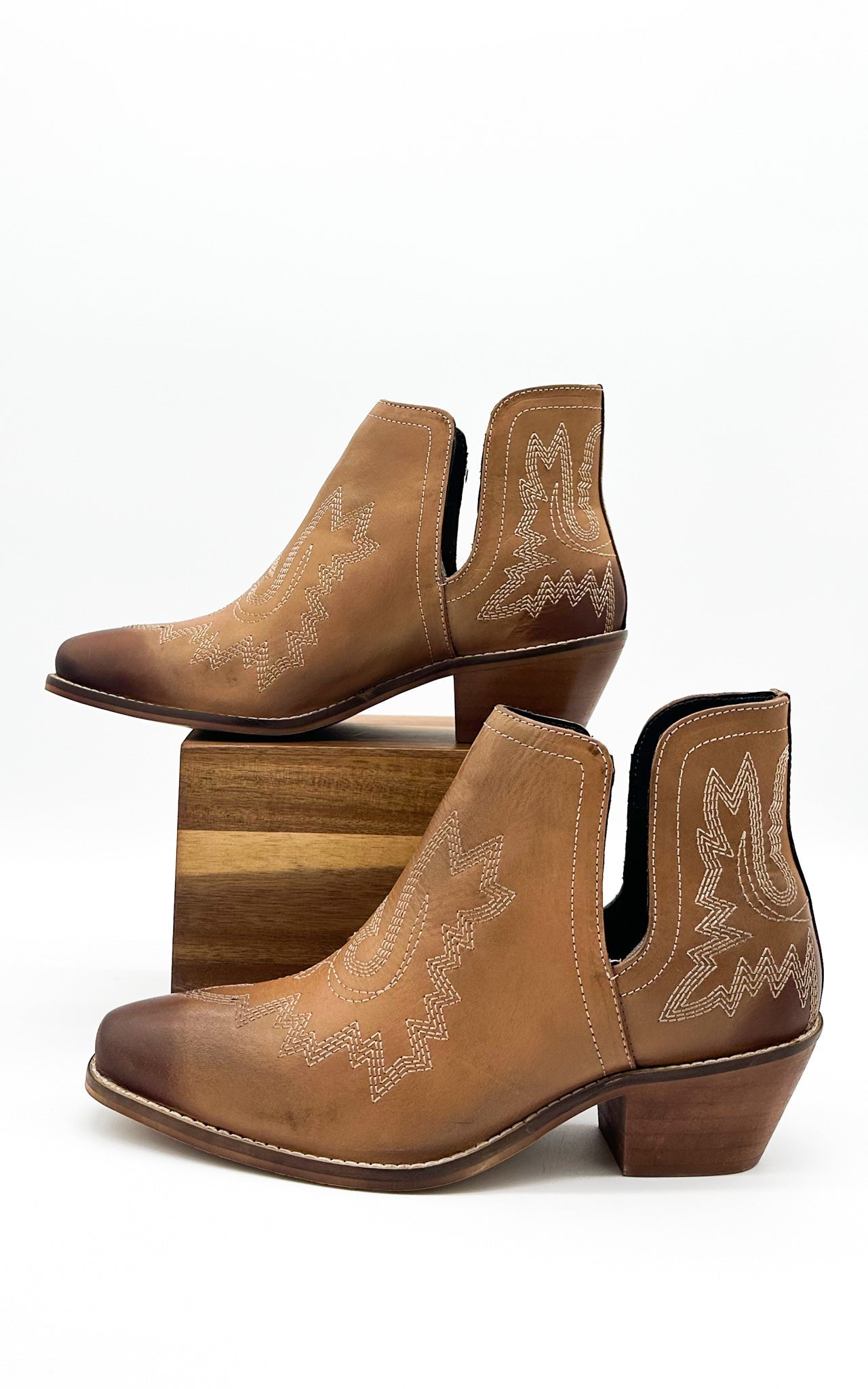 Tan leather booties with Western embroidery, roomy snip toe, cushioned footbed, and ankle slits.