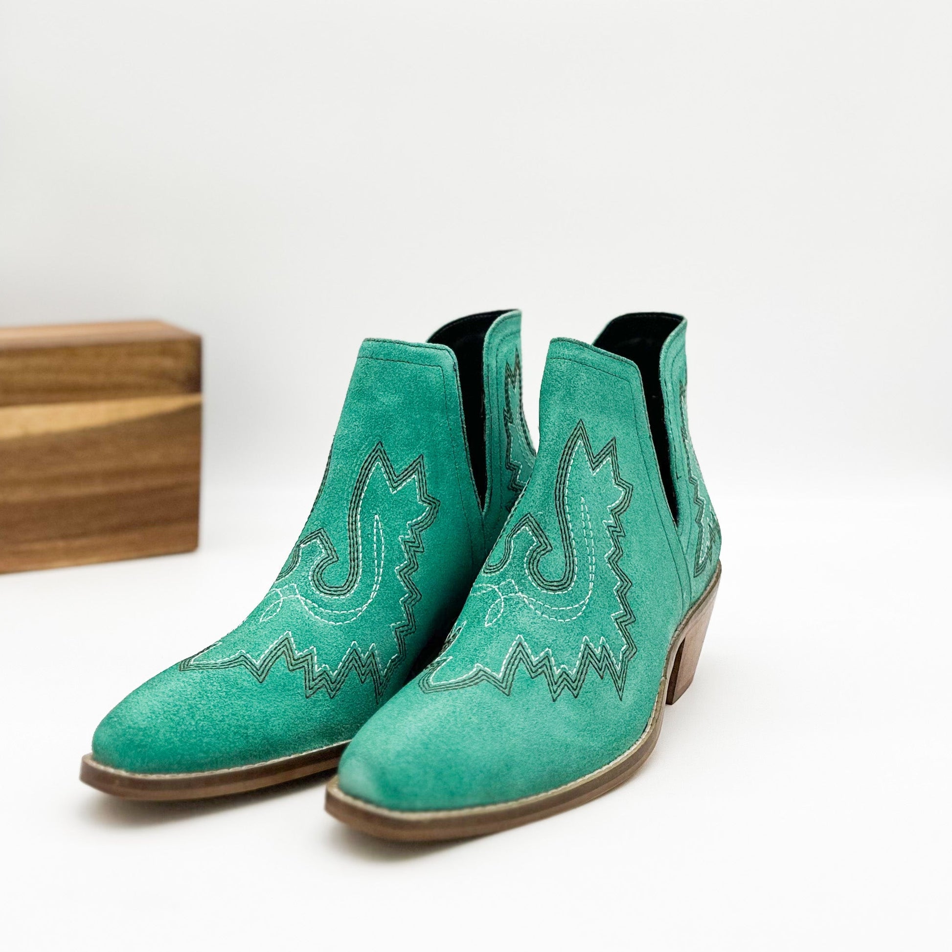 Turquoise leather booties with Western embroidery, roomy snip toe, cushioned footbed, and ankle slits.