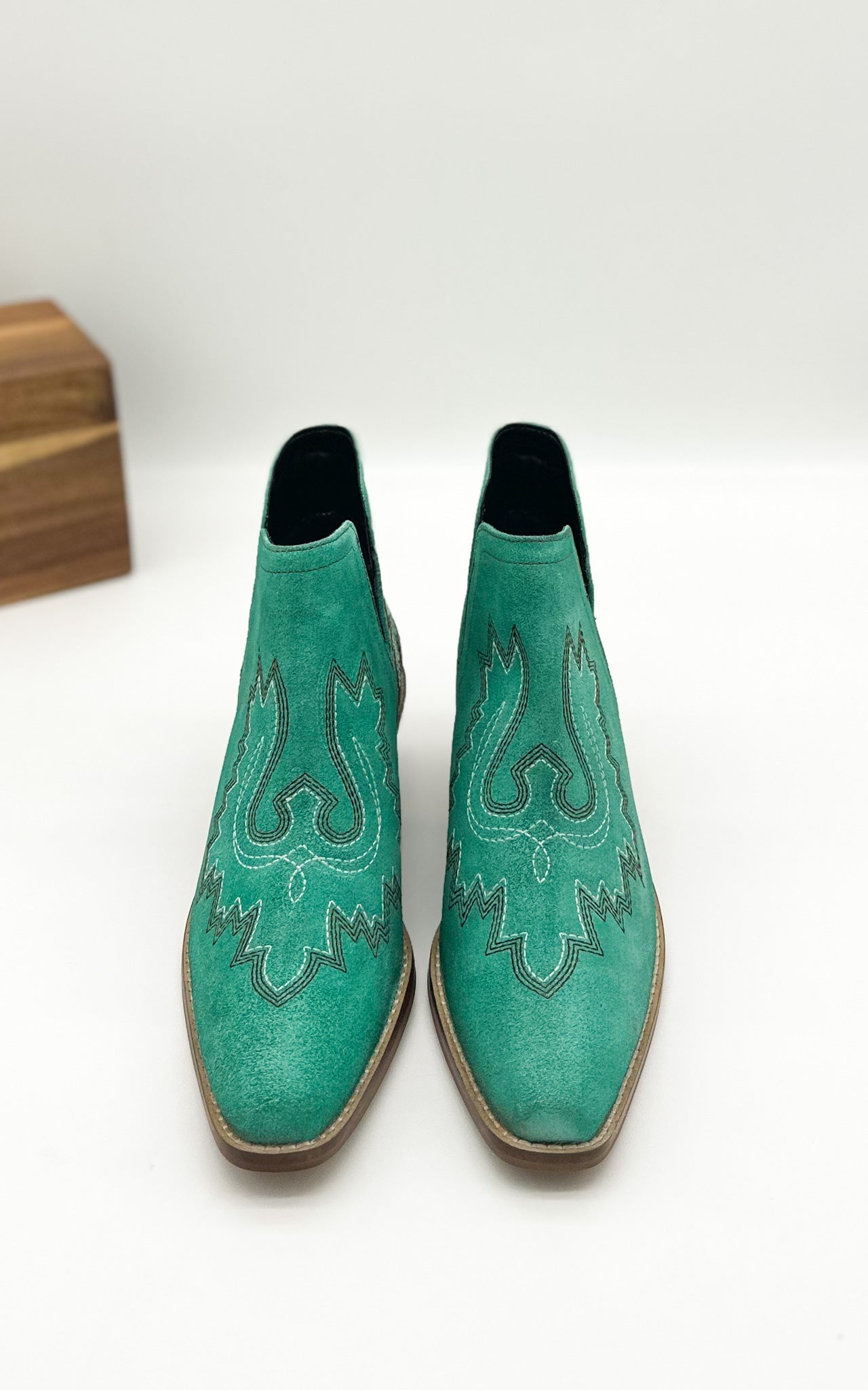 Turquoise leather booties with Western embroidery, roomy snip toe, cushioned footbed, and ankle slits.