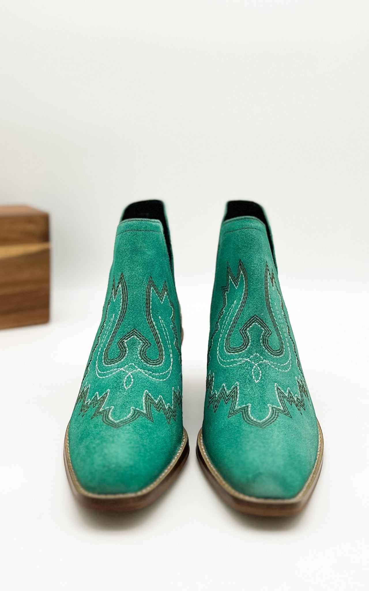 Turquoise leather booties with Western embroidery, roomy snip toe, cushioned footbed, and ankle slits.