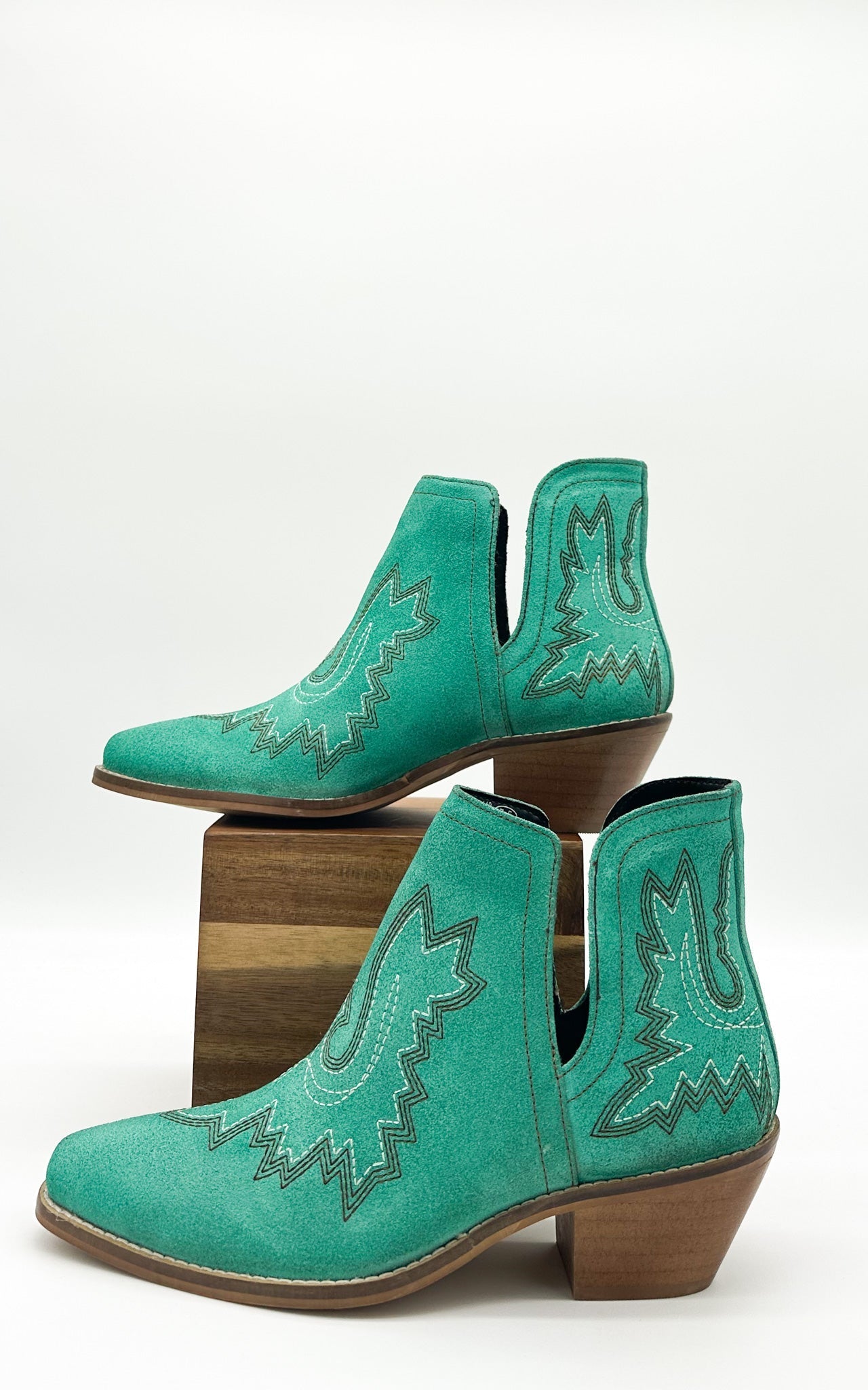 Turquoise leather booties with Western embroidery, roomy snip toe, cushioned footbed, and ankle slits.