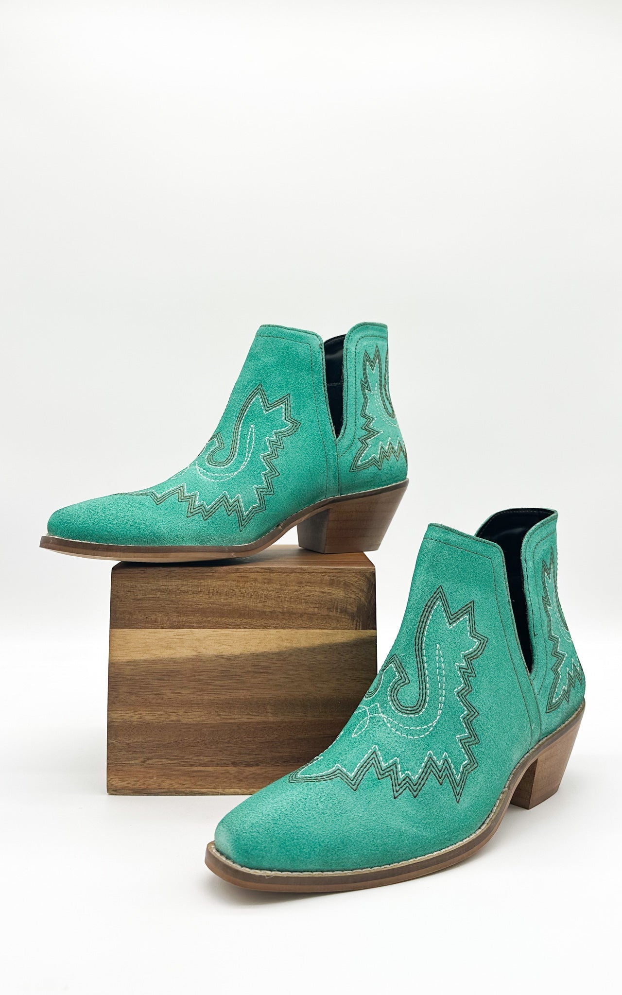 Turquoise leather booties with Western embroidery, roomy snip toe, cushioned footbed, and ankle slits.