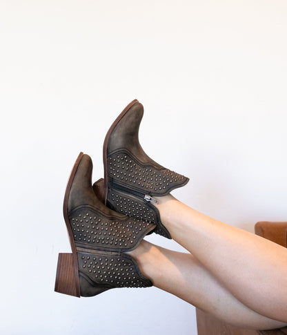 Woman wearing Nellie Studded Ankle Boots in black leather with studded accents and Western style.