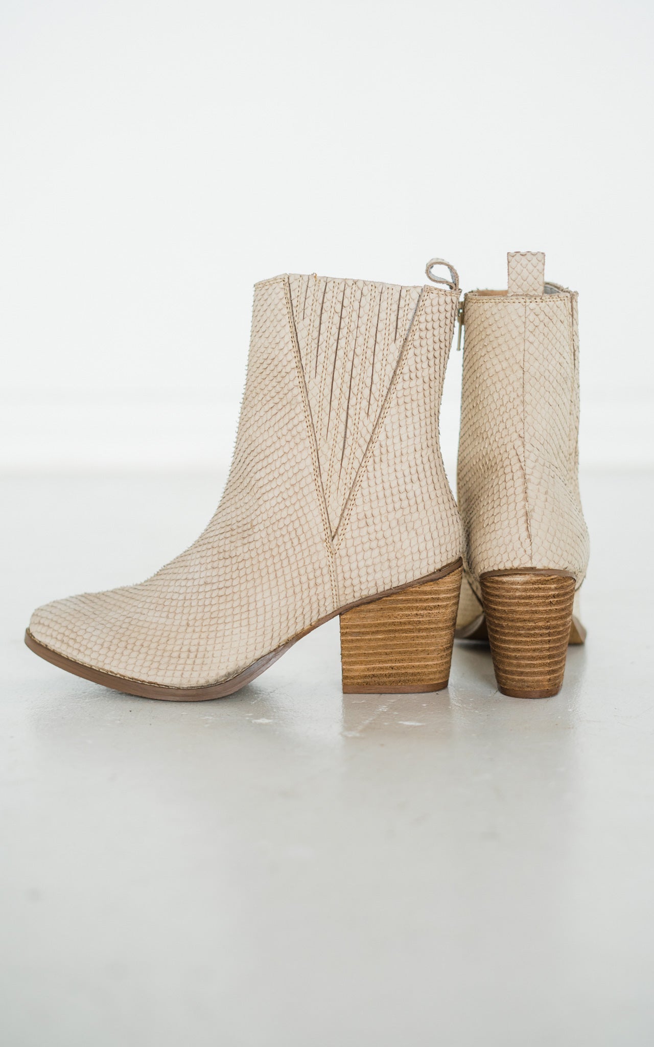 Women's cream ankle boots with a genuine leather upper, snakeskin leather detailing, inside zipper, cushioned footbed, and a 2.75-inch heel.