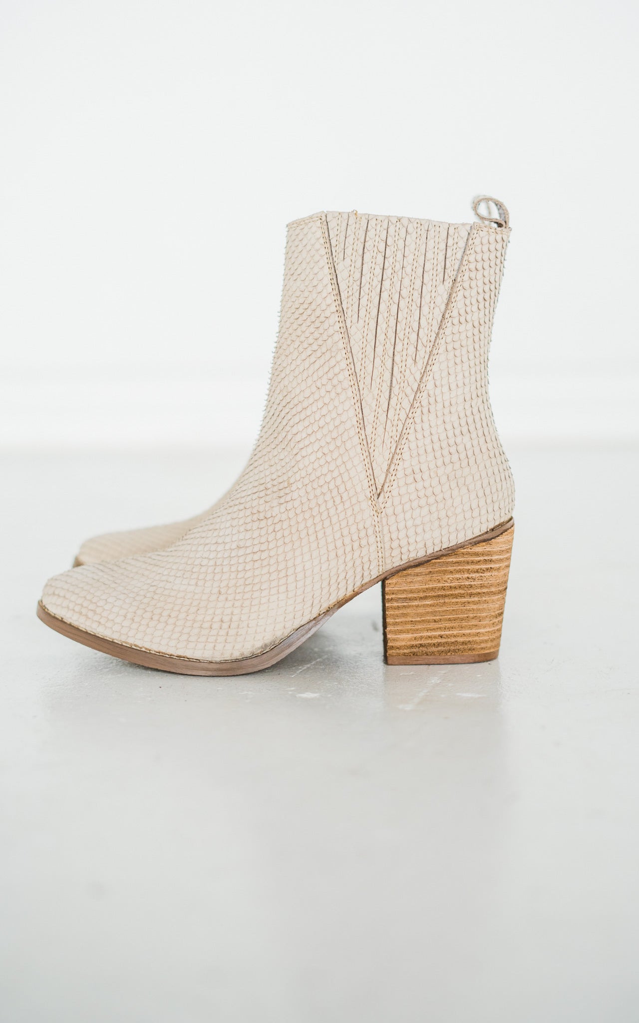 Women's cream ankle boots with a genuine leather upper, snakeskin leather detailing, inside zipper, cushioned footbed, and a 2.75-inch heel.