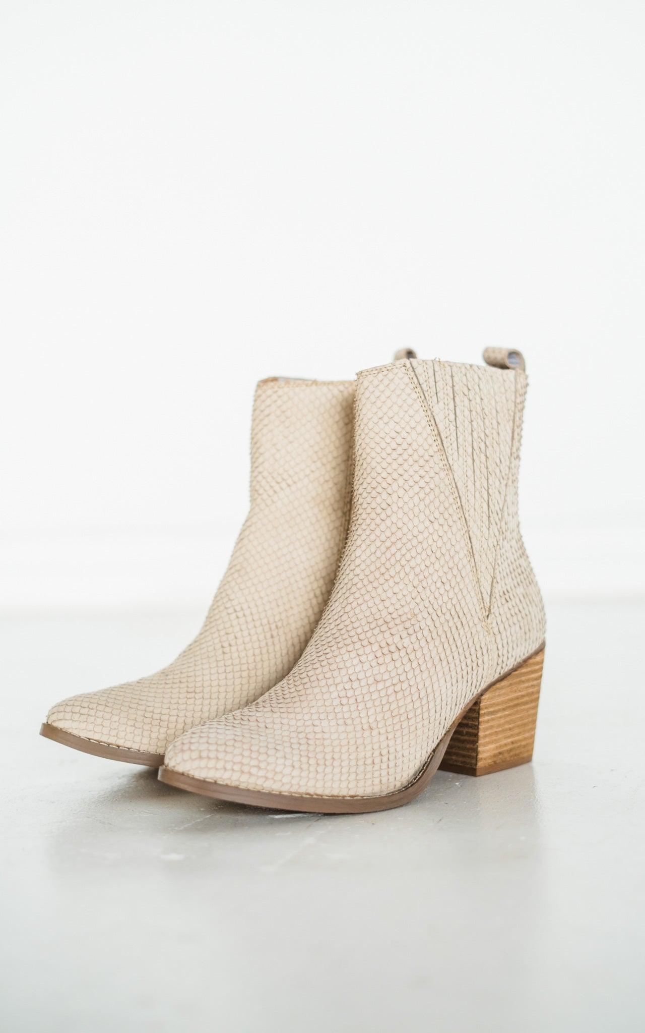 Women's cream ankle boots with a genuine leather upper, snakeskin leather detailing, inside zipper, cushioned footbed, and a 2.75-inch heel.