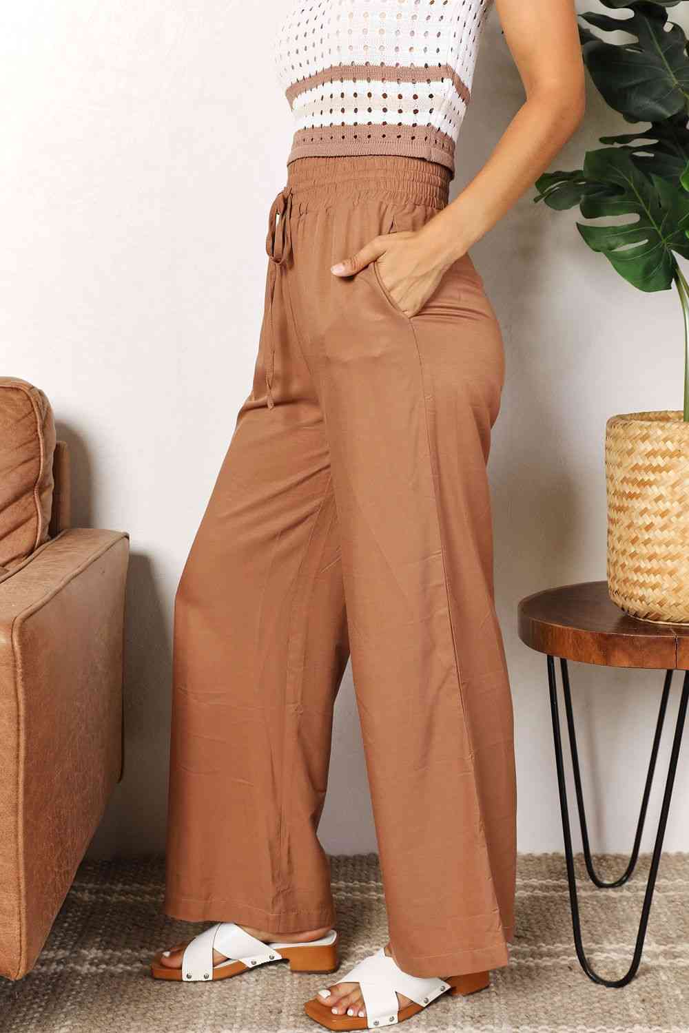 Camel colored, wide-leg pants with a drawstring-smocked waist.