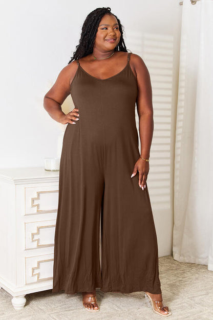 Plus size model in mocha wide-leg jumpsuit with pockets and adjustable straps.