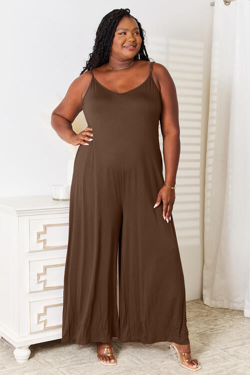 Plus size model in mocha wide-leg jumpsuit with pockets and adjustable straps.