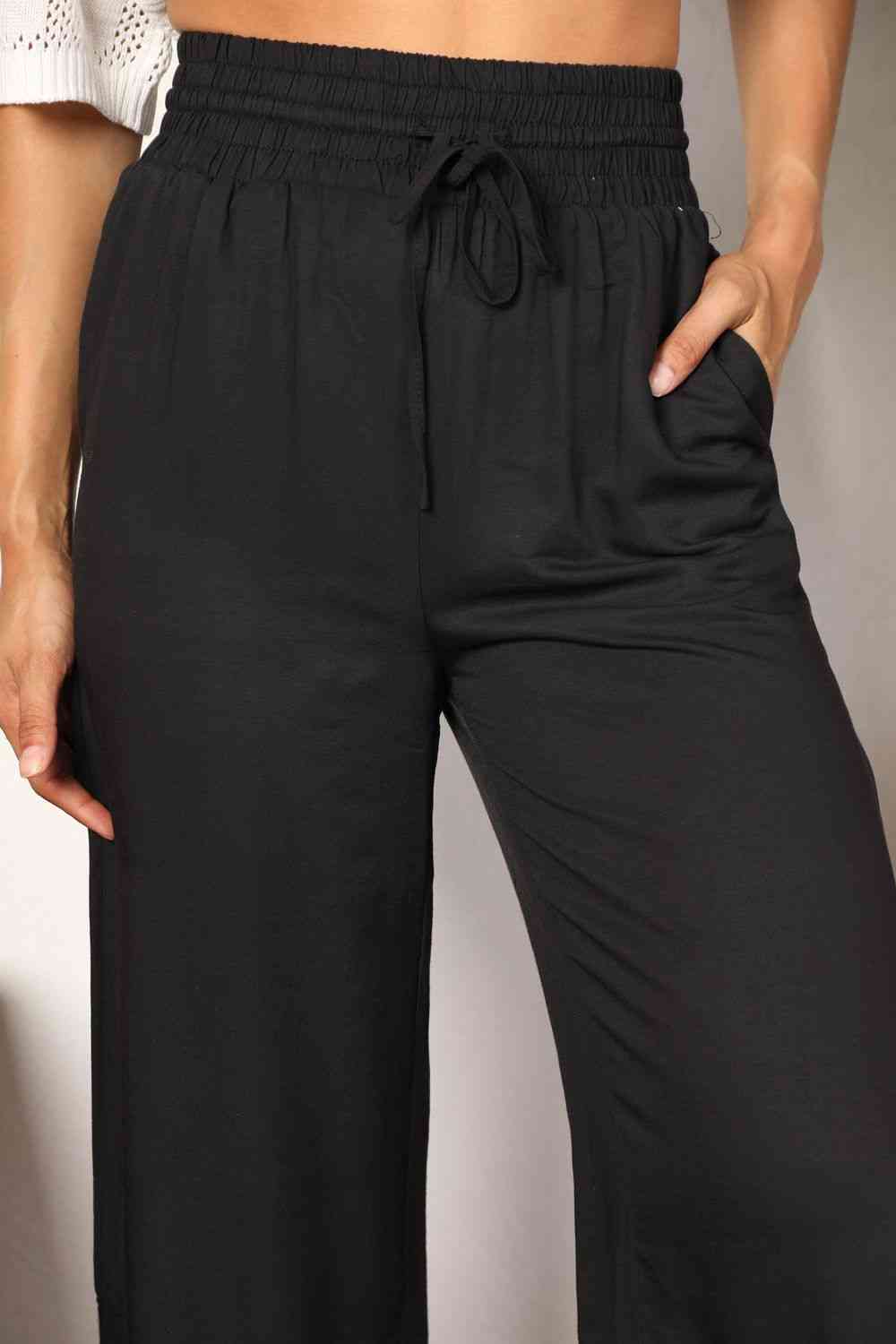 Black wide-leg pants with a drawstring-smocked waist.