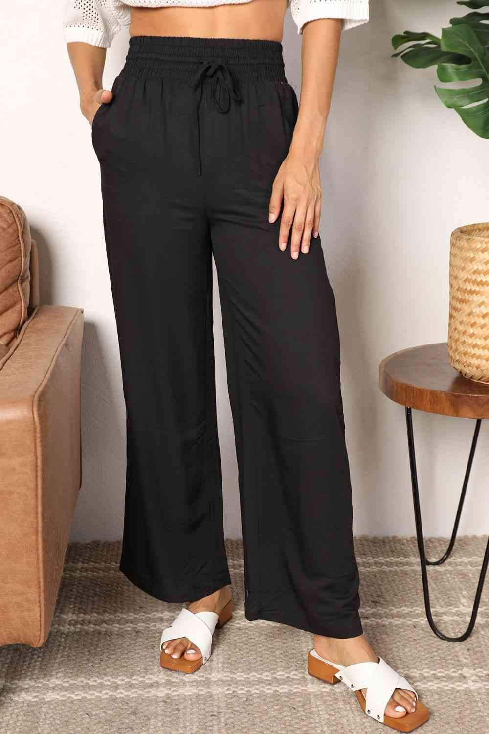 Black wide-leg pants with a drawstring-smocked waist.