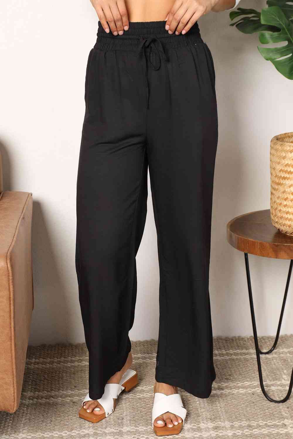 Black wide-leg pants with a drawstring-smocked waist.