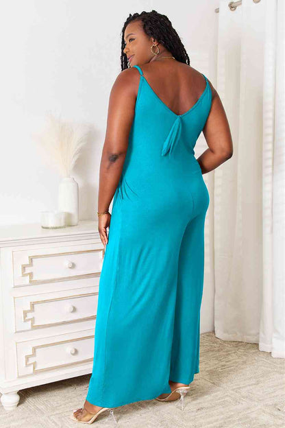 Back view of plus size sky blue jumpsuit showing tie detail at the back and relaxed fit.