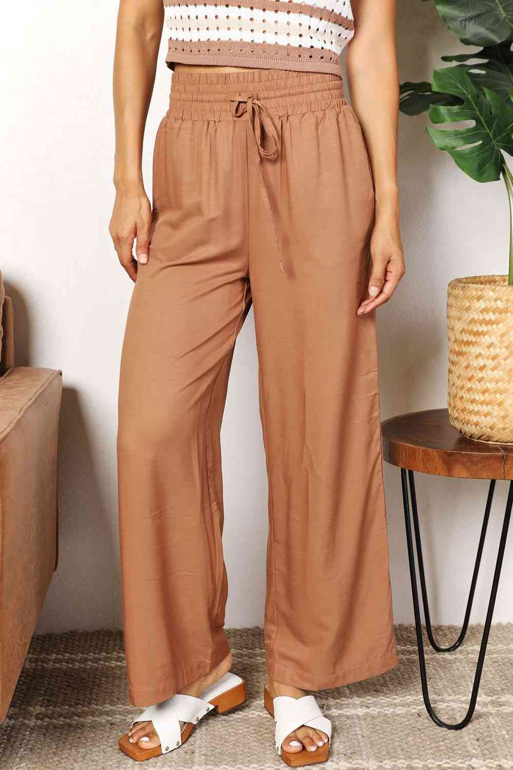 Camel colored, wide-leg pants with a drawstring-smocked waist.