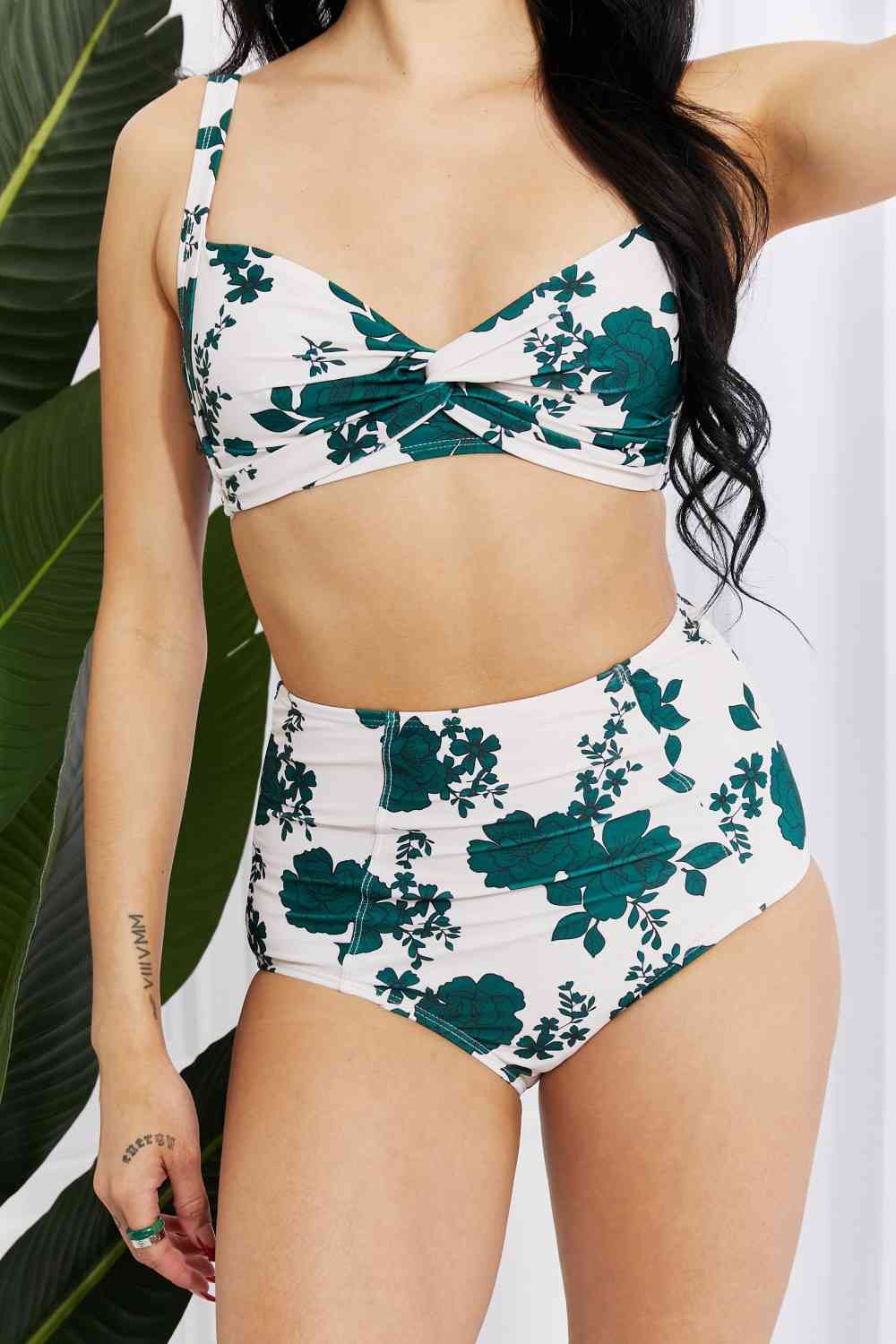 This Forest high-waisted bikini set features a stylish twist-front top with removable padding, paired with high-rise bottoms for a chic, comfortable fit. The floral design adds a touch of elegance to this summer essential.