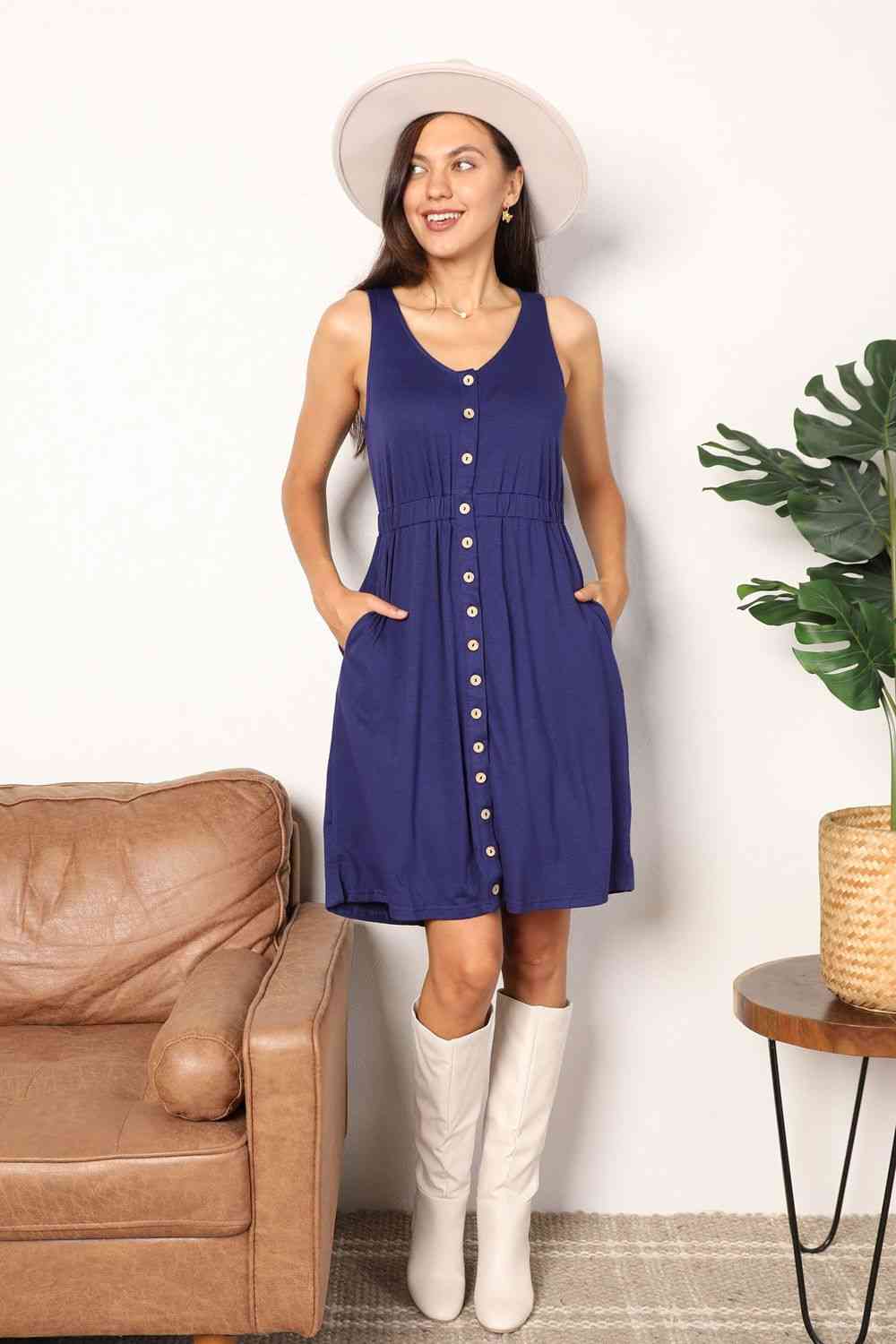 Navy sleeveless dress with a button front, empire waist, and pockets.